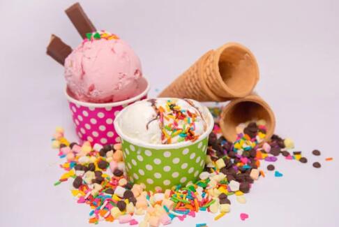 Picture of Ice Cream in a decorative cups and empty cones and sprinkles sounding the cups.