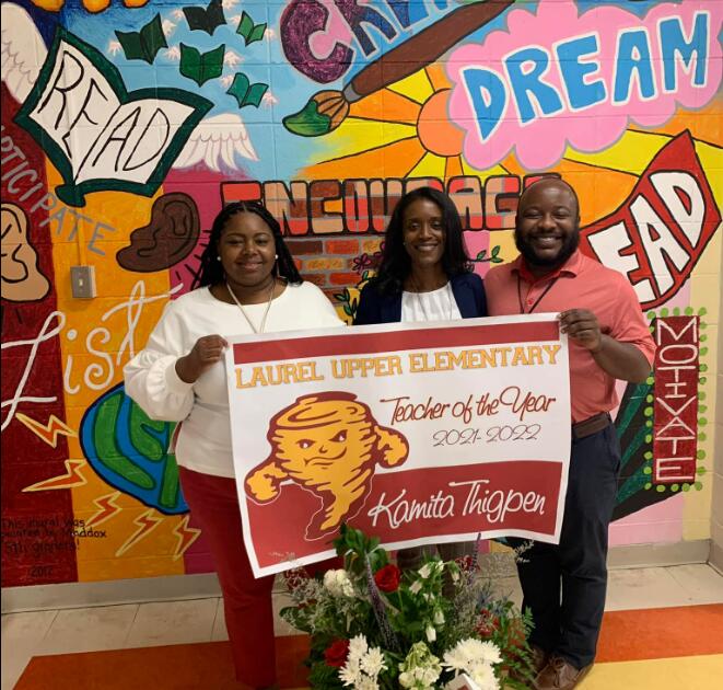 Three adults holding up teacher of the year sign