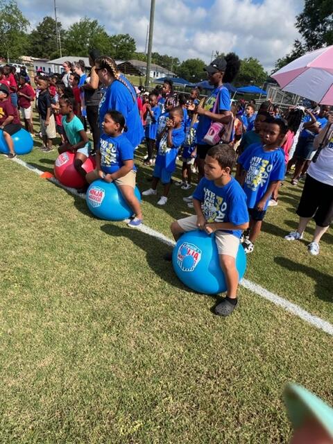 Children outside sitting on bouncy balls